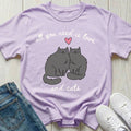 Purple t-shirt with cat design and text 'all you need is love and cats' on a wooden surface with jeans and sneakers.